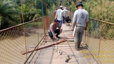 Bhabinkamtibmas Polsek Medang Deras Bantu Perbaikan Jembatan