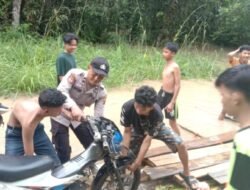 Bhabinkamtibmas Bantu Pengguna Jalan Tergenang Air
