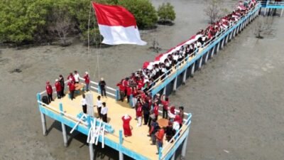 Wabup Asahan dan Ratusan Pelajar Bentangkan Bendera 20 Meter di Mangrove Silo Baru